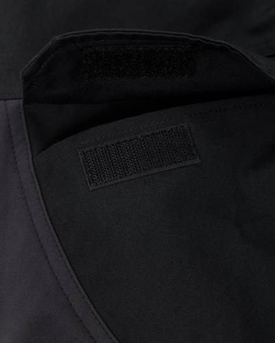 Nahaufnahme eines schwarzen Stoffes mit Klettverschlussstreifen, die die strukturierte Oberfläche und Nahtdetails zeigt.