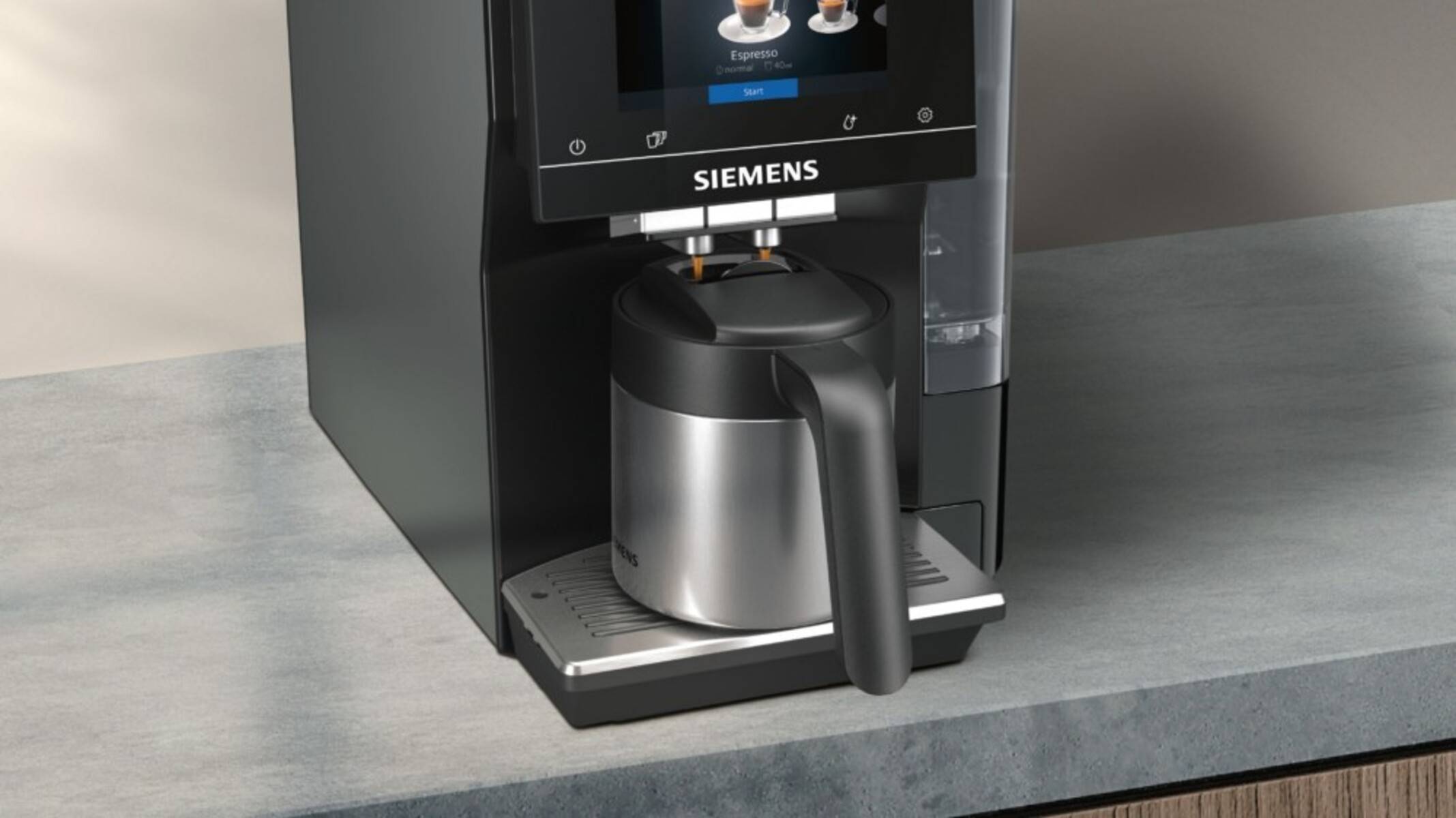 Eine schwarze Siemens-Kaffeemaschine brüht Espresso in eine Edelstahlkanne auf einer Arbeitsplatte. Ein digitales Display zeigt Espresso-Optionen an.