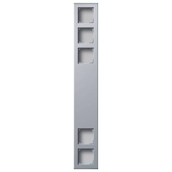 Ein vertikales silbernes Panel mit vier gleichmäßig angeordneten quadratischen Ausschnitten.
