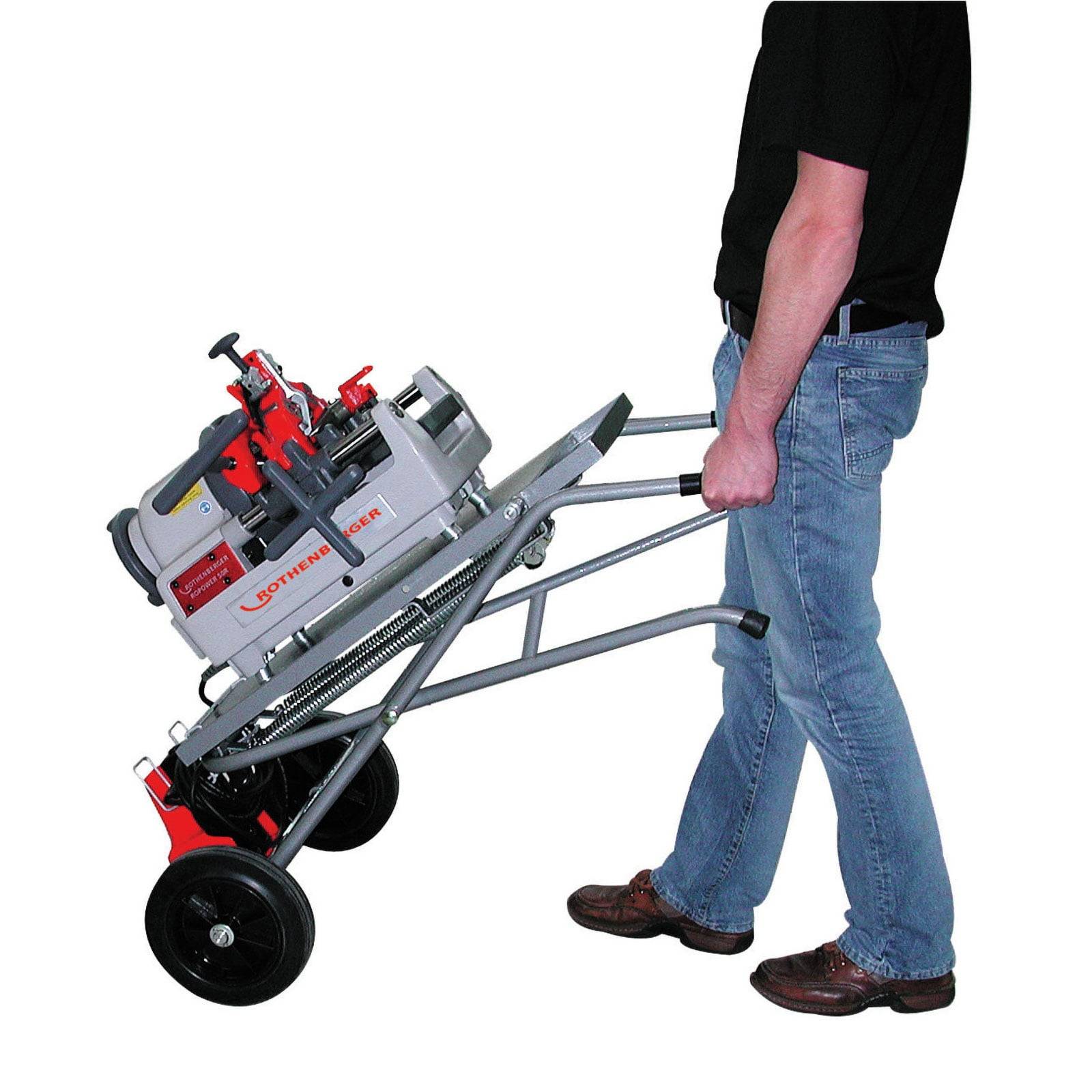 Eine Person transportiert eine schwere Rohrgewindemaschine auf einem Rollwagen, was ihre Mobilität und ergonomische Gestaltung unterstreicht.