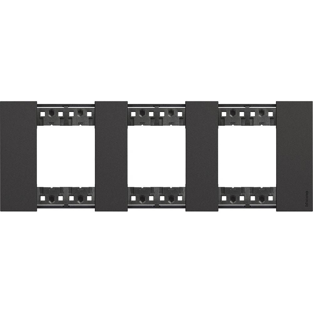 Ein horizontales schwarzes Panel mit vier rechteckigen Schlitzen, höchstwahrscheinlich ein Schalter- oder Steckdosenrahmen für elektrische Installationen.