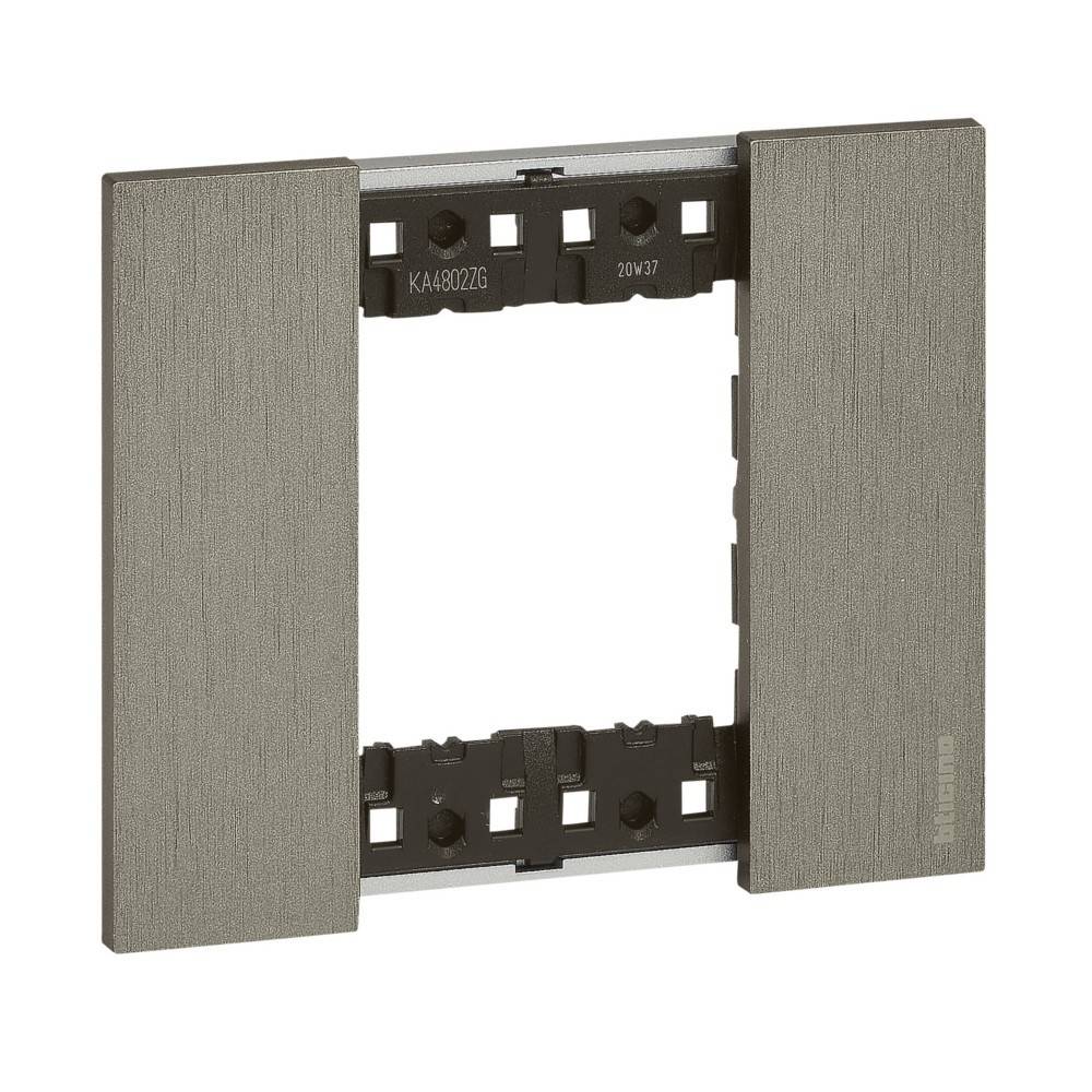 Ein Metallrahmen, der zum Anbringen von elektrischen Schaltern oder Steckdosen entwickelt wurde, mit einer texturierten Oberfläche und einem modernen, minimalistischen Stil.