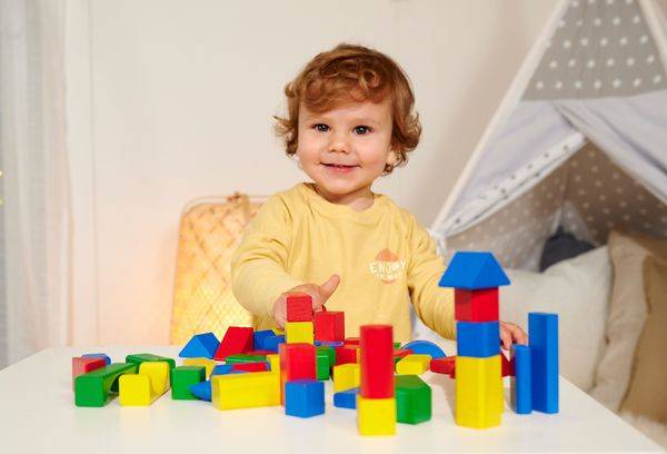 Eine Nahaufnahme eines kleinen Elektromotors mit sichtbaren Zahnrädern und Drähten, der an einer schwarzen Halterung befestigt ist, wahrscheinlich Teil eines Robotik- oder Elektronikprojekts.