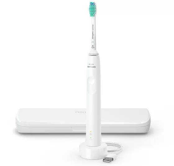 Weiße Philips-Elektrozahnbürste, die auf einer Ladestation steht, mit einer Reisetasche dahinter und einem USB-Ladekabel davor.