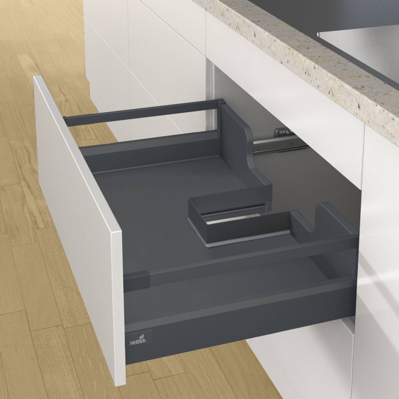 Offene Küchenschublade neben einer Arbeitsplatte, die ein elegantes Design mit integrierten Schienen zur Organisation zeigt. Weiße Schrankfronten und Holzfußboden.
