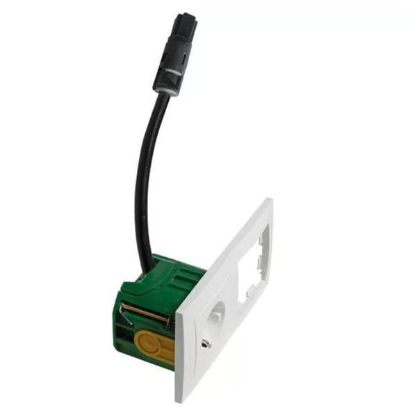 Grünes wandmontiertes Elektrosteckverbindermodul mit schwarzem Kabel und weißer Frontplatte auf neutralem Hintergrund.