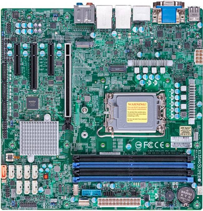 Computerplatine mit CPU-Sockel, RAM-Steckplätzen, Erweiterungssteckplätzen, Anschlüssen, Chipset-Kühlkörpern und Verbindungselementen auf einer grünen Leiterplatte.