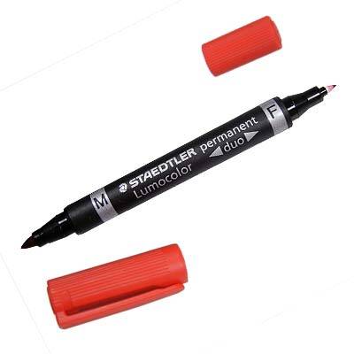 Schwarzer Staedtler Permanent Duo Marker mit feiner und breiter Spitze, gezeigt mit zwei roten Kappen auf weißem Hintergrund.
