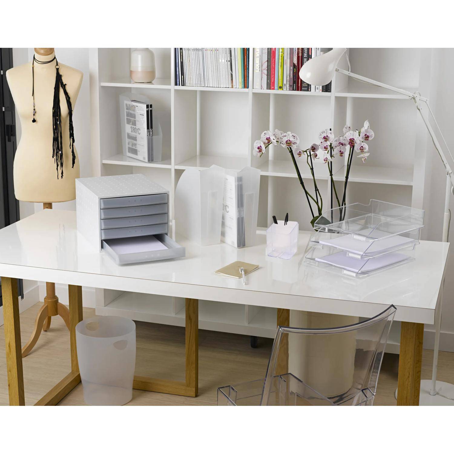 Minimalistisches weißes Heimbüro oder Handwerkstisch mit Regalen, Schneiderpuppe, Lampe, Orchidee und Papierorganizern in einem aufgeräumten Arbeitsbereich.