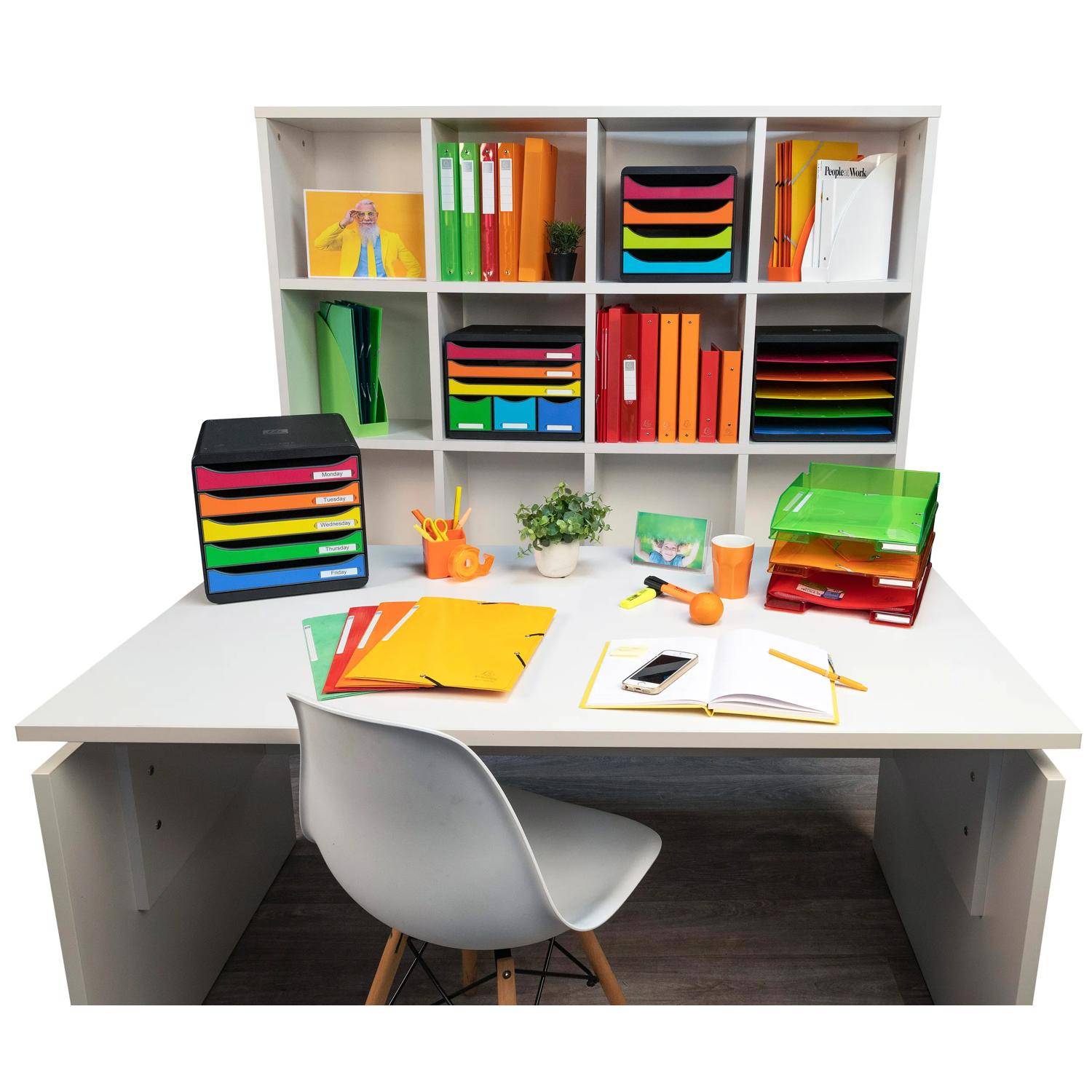 Organisierter Bürotisch mit Stuhl, Bücherregal mit farbenfrohen Dateien und Tabletts sowie Schreibwaren auf dem Tisch, was einen ordentlichen Arbeitsplatz suggeriert.