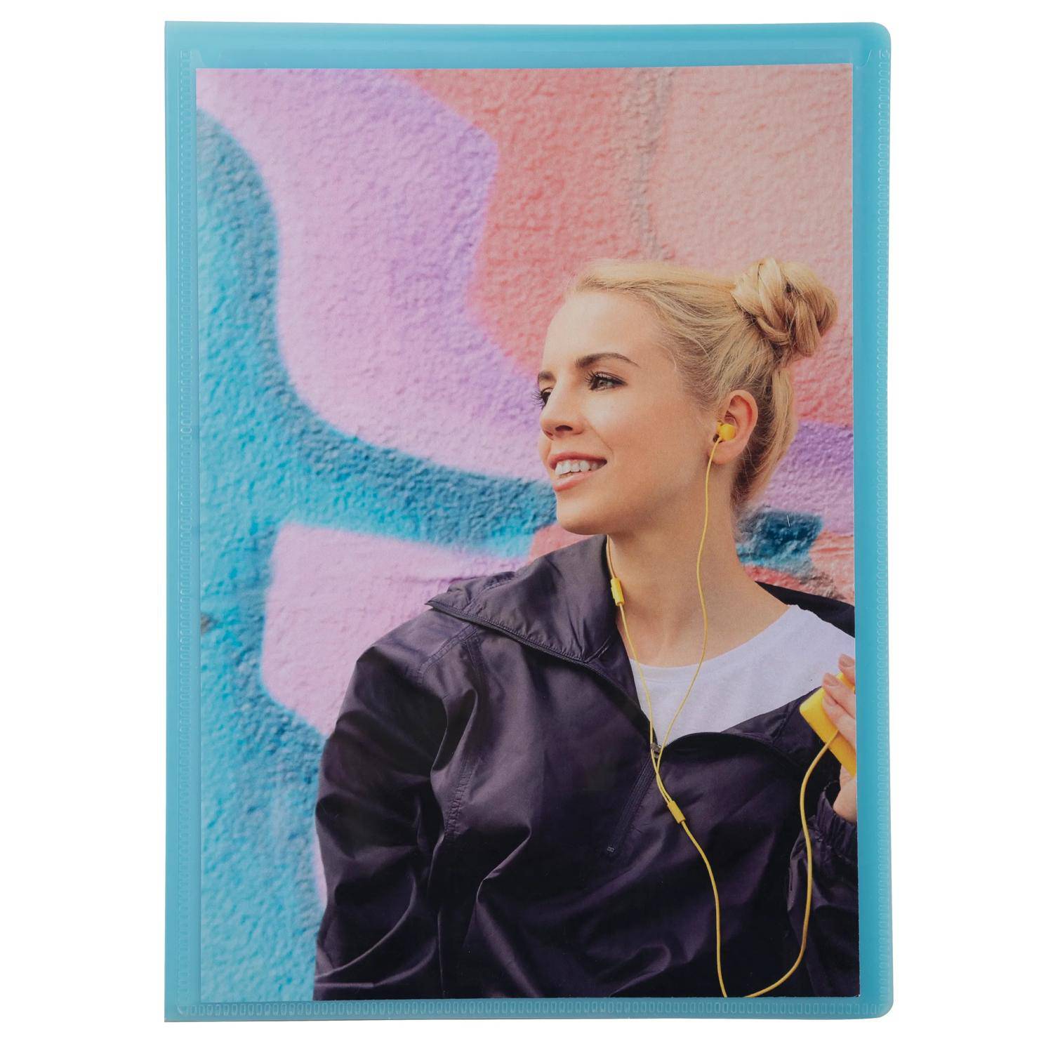 Porträt einer lächelnden blonden Frau mit gelben Kopfhörern, die eine dunkle Jacke trägt und vor einer farbenfrohen Graffiti-Wand steht.