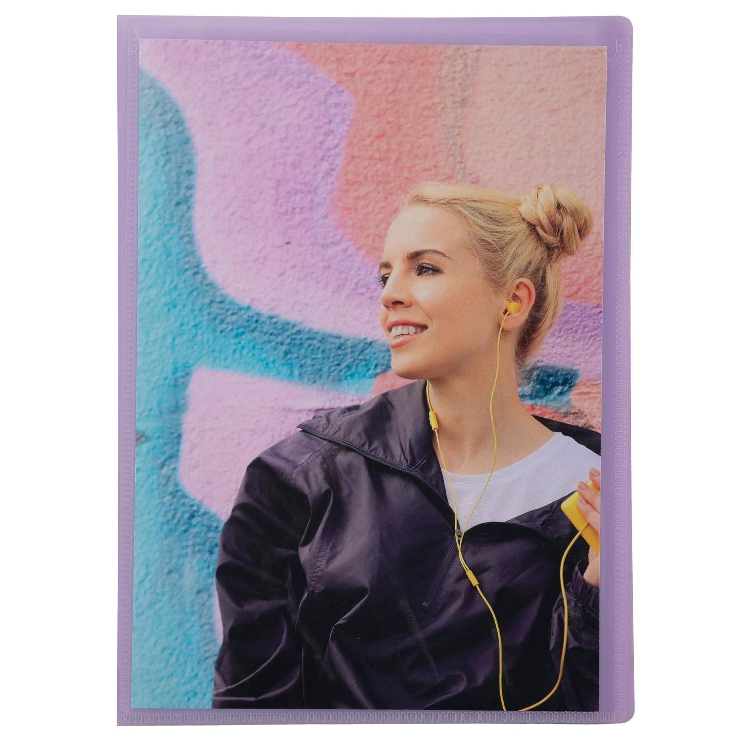 Lächelnde blonde Frau in einer schwarzen Jacke mit gelben Kopfhörern, die vor einer bunten Graffiti-Wand steht.