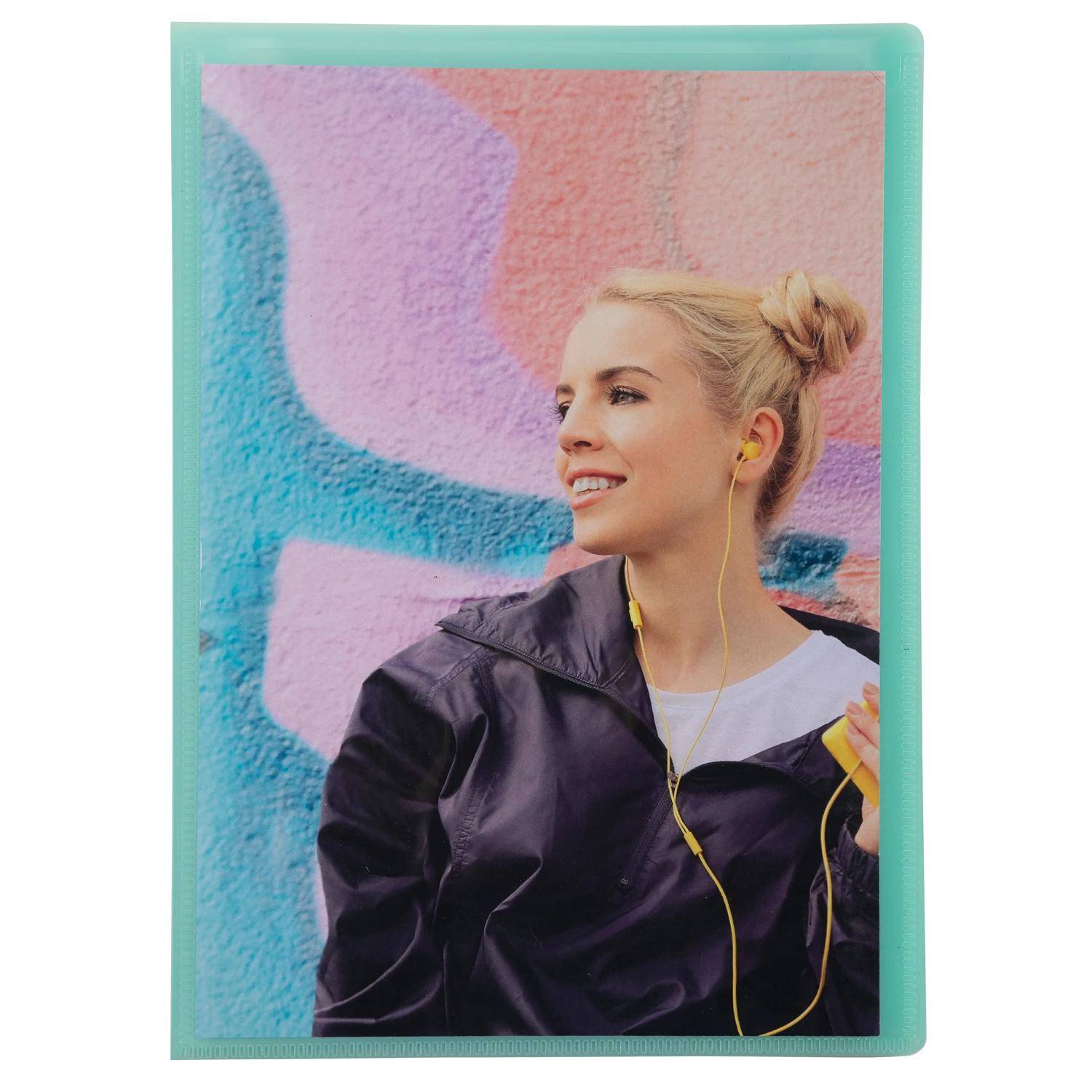 Porträt einer lächelnden Frau in einer schwarzen Jacke mit gelben Kopfhörern vor einer bunten Graffiti-Wand.