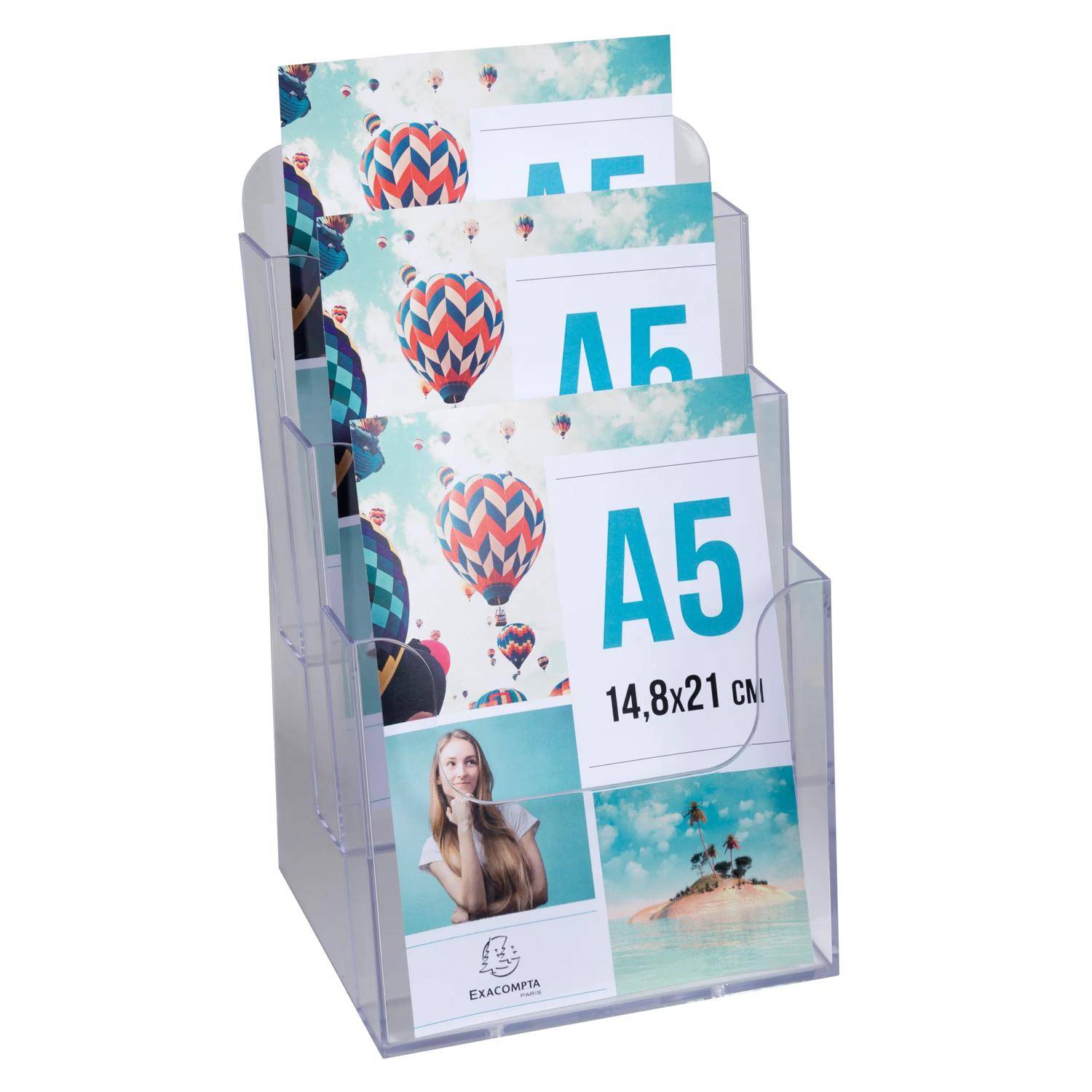 Durchsichtiger Acryl-Broschürenständer mit mehreren A5-Flyern, die Heißluftballons, eine Frau und einen Strand zeigen; das vordere Flugblatt ist mit „A5 14,8x21 cm" und „EXACOMPTA"" gekennzeichnet.