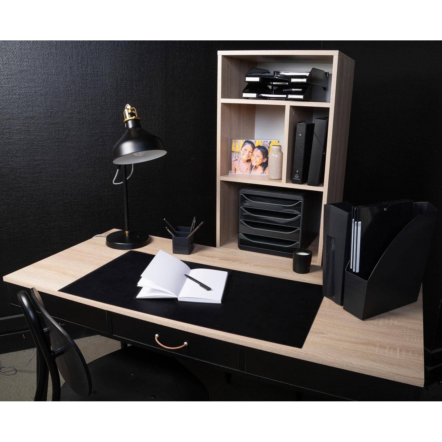 Ordentlicher Homeoffice-Schreibtisch mit schwarzer Lampe, aufgeschlagenem Notizbuch, Stuhl und Regaleinheit mit Dateien und einem Fotorahmen.