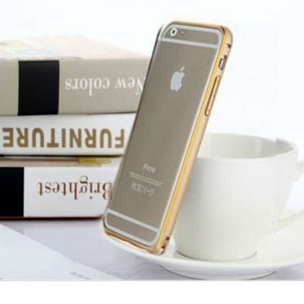 Ein goldenes iPhone lehnt an einer weißen Tasse mit Untertasse neben gestapelten Büchern auf einer hell leuchtenden Tischplatte.