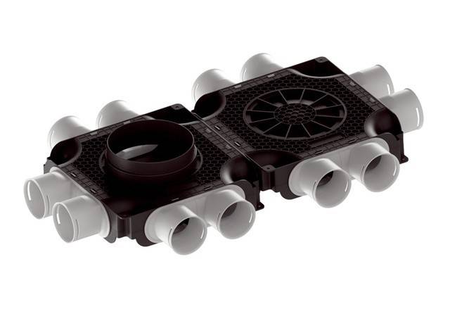 Eine schwarz-weiße mechanische Komponente mit Lüftungsschlitzen und kreisförmigen Öffnungen, höchstwahrscheinlich ein Rohranschluss oder Teil eines Belüftungssystems.