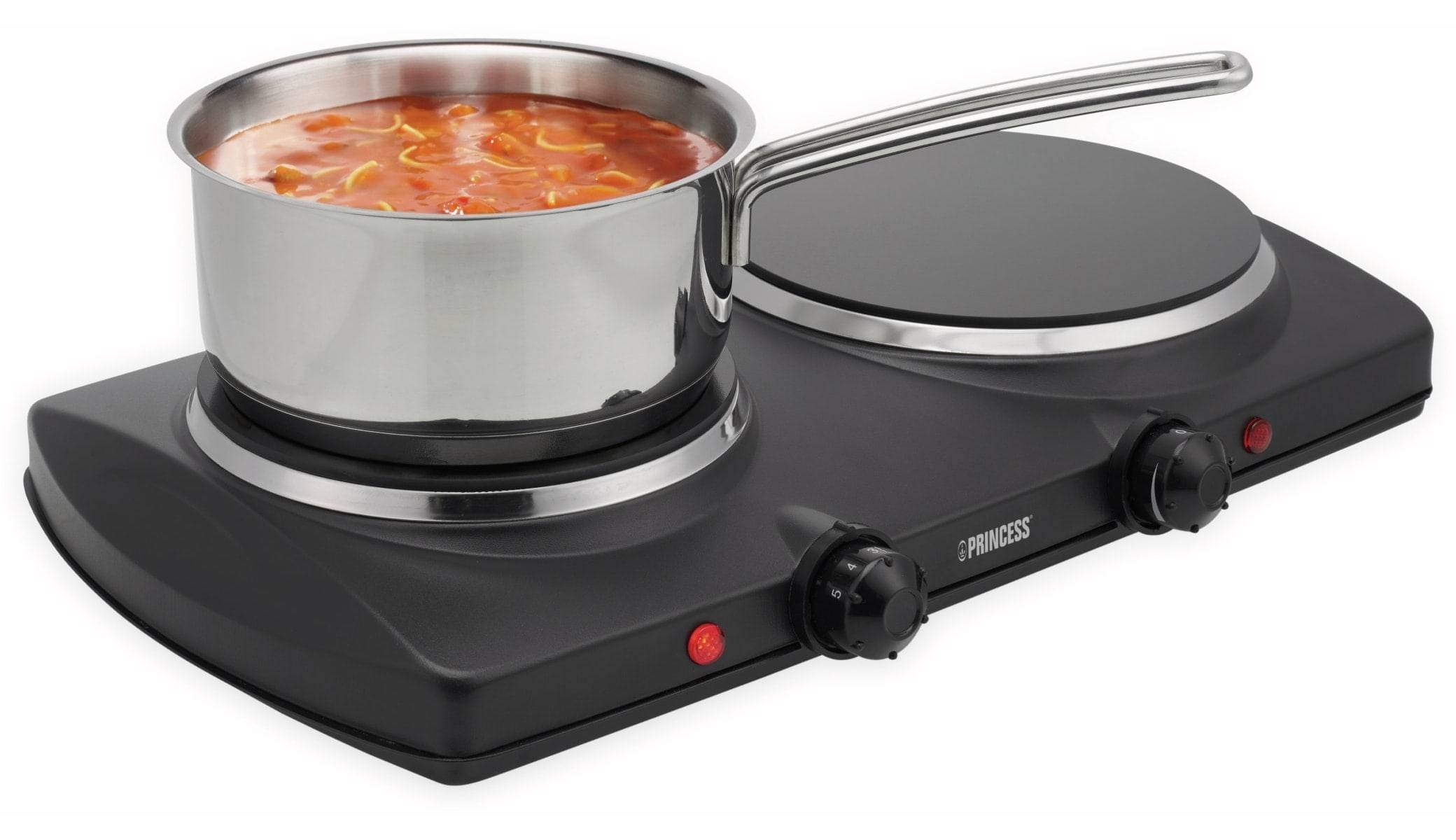 Ein Kochtopf mit Tomatensuppe auf einem schwarzen tragbaren elektrischen Herd mit zwei Kochplatten und Bedienungsknöpfen.