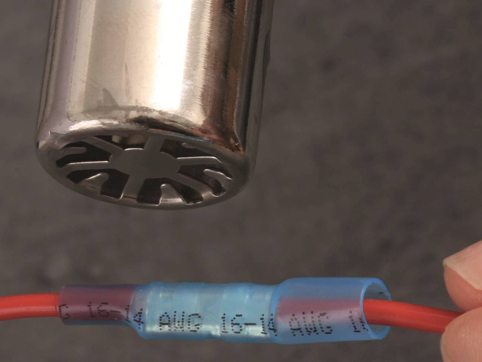 Ein mit Metall geflochtener Schlauch neben einem blauen Anschluss mit der Bezeichnung „16-14 AWG