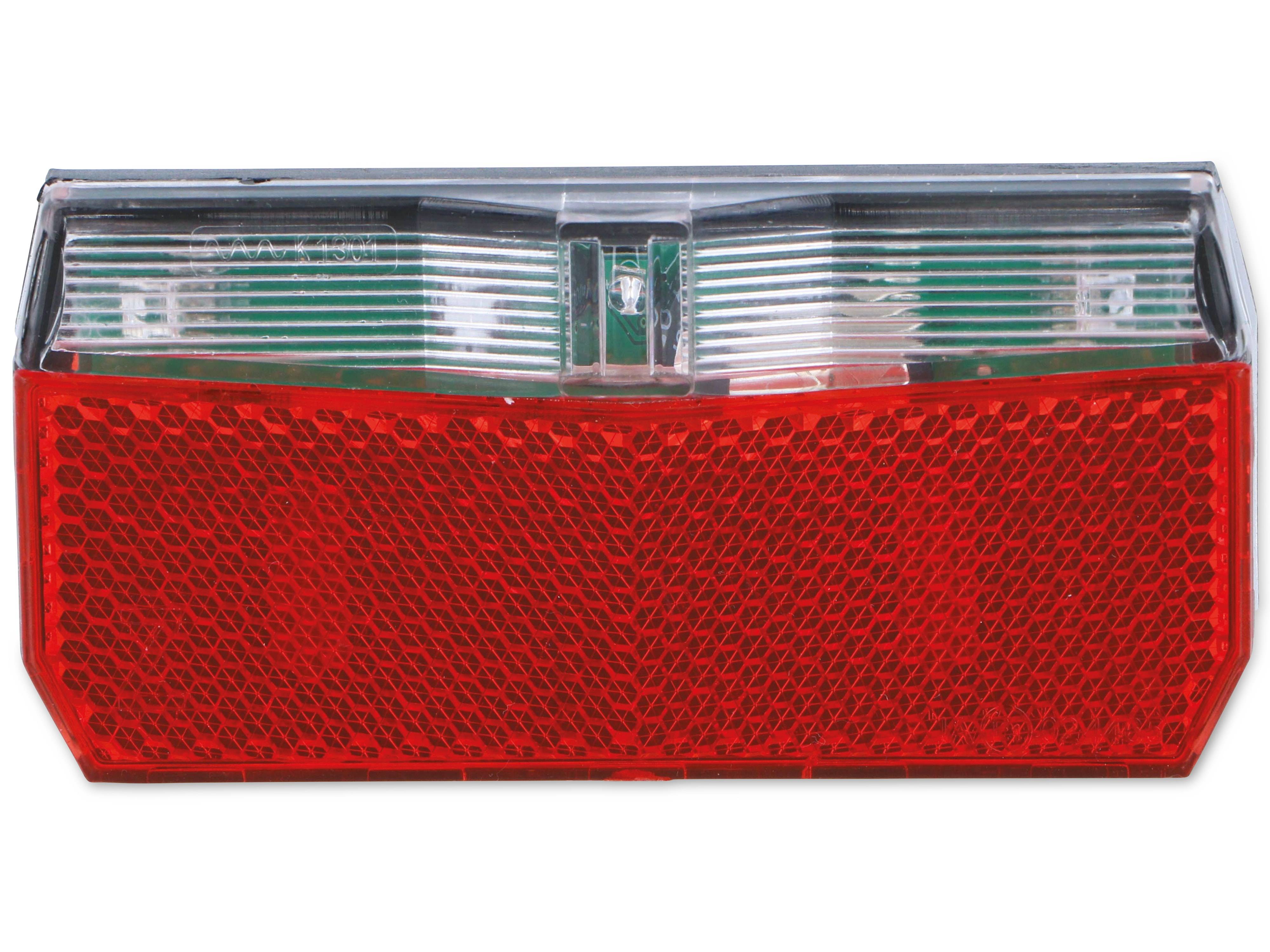 Eine Nahaufnahme eines roten Reflektors mit strukturierter Oberfläche, die üblicherweise auf Fahrzeugen zur Verbesserung der Rücksichtbarkeit und Verkehrssicherheit verwendet wird.