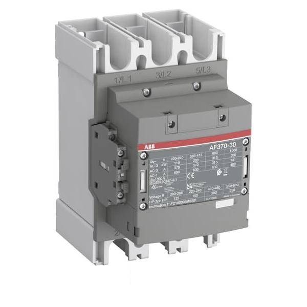 Ein grauer elektrischer Schütz mit einem schwarzen Etikett, das technische Spezifikationen und Modellnummer zeigt.
