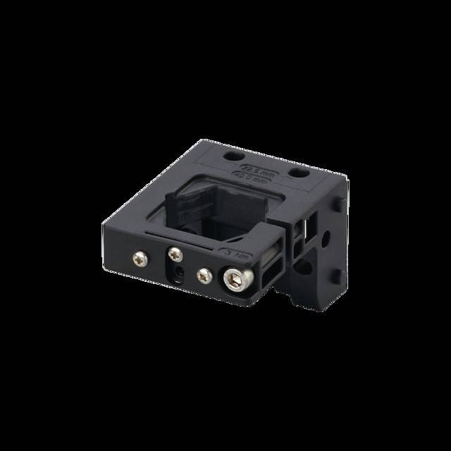 Eine schwarze Halterung für einen Sensor oder ein elektronisches Gerät mit mehreren Löchern und Schlitzen für Schrauben, die ein kompaktes und funktionales Design aufweist.