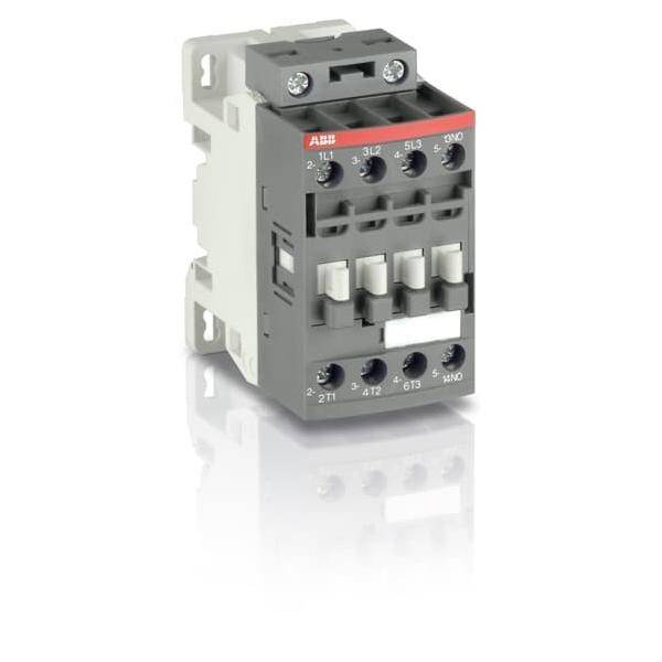 Ein kleiner, grauer elektrischer Schütz mit sichtbaren Anschlüssen und einem roten Etikett auf der Oberseite, der zur Steuerung elektrischer Stromkreise verwendet wird.