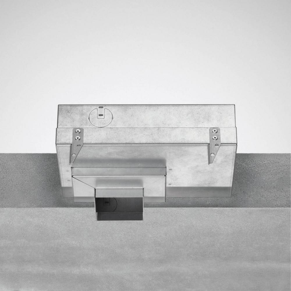 Eine rechteckige, metallische Schachtel mit Halterungen, die auf einer grauen Betonoberfläche montiert ist und eine kleine rechteckige Öffnung an ihrer Basis aufweist.