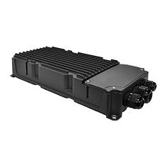 Ein schwarzes, geripptes elektronisches Gerät mit Anschlüssen an der Seite, das wie ein robustes Outdoor- oder Industriegehäuse aussieht, vor einem dunklen Hintergrund.