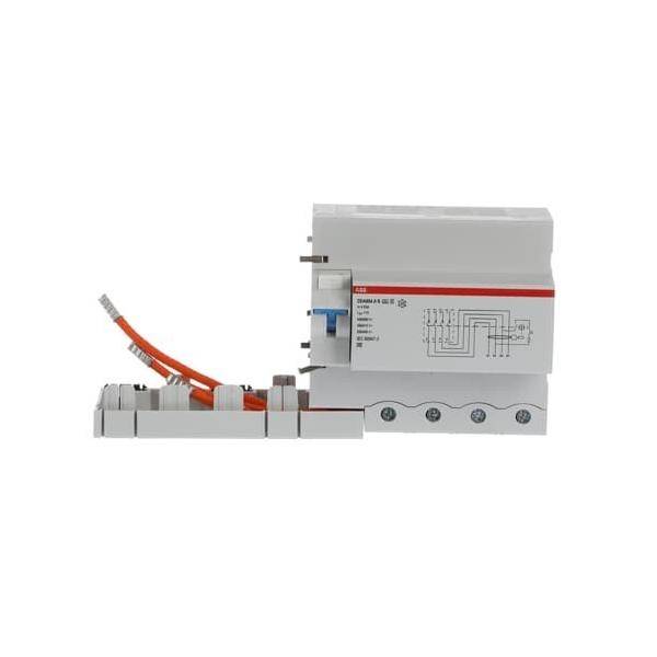 Ein weißes elektrisches Gerät mit mehreren Anschlüssen und einer Diagram auf der Seite, das mit einem orangefarbenen Kabel verbunden ist, höchstwahrscheinlich ein Sicherungsautomat oder Relais.