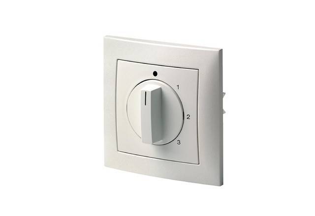 Ein weißer Drehschalter an einer Wand, beschriftet mit den Zahlen 0 bis 3, die verschiedene Einstellungen oder Geschwindigkeiten anzeigen.