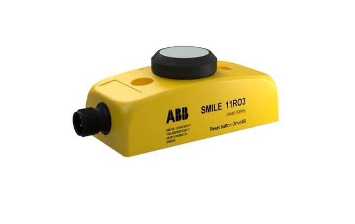 Ein gelbes Sicherheitskontrollgerät mit einem schwarzen Knopf und Anschluss, gekennzeichnet als 'ABB SMILE 11RO3, Jokab Safety', enthält einen 'Reset-Knopf Orion3B'.
