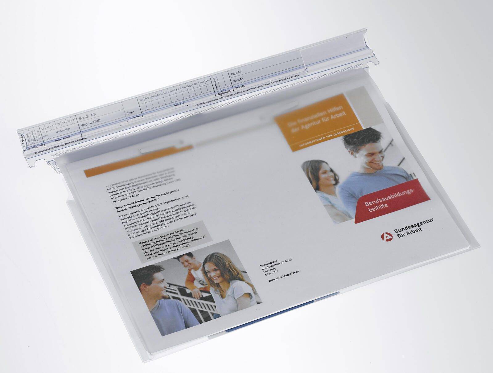Eine transparente Kunststoff-Präsentationsmappe mit Broschüren und einem Broschürencover, das Fotos von Menschen, deutschen Text und das Logo der Bundesagentur für Arbeit zeigt.