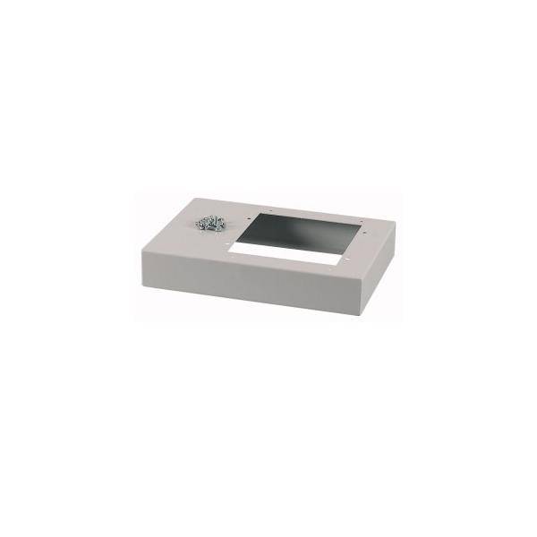 Eine rechteckige Installationsbox mit einer Aussparung in der Mitte und einem kleinen Haufen Schrauben auf der linken Seite, verwendet für elektrische Installationen.