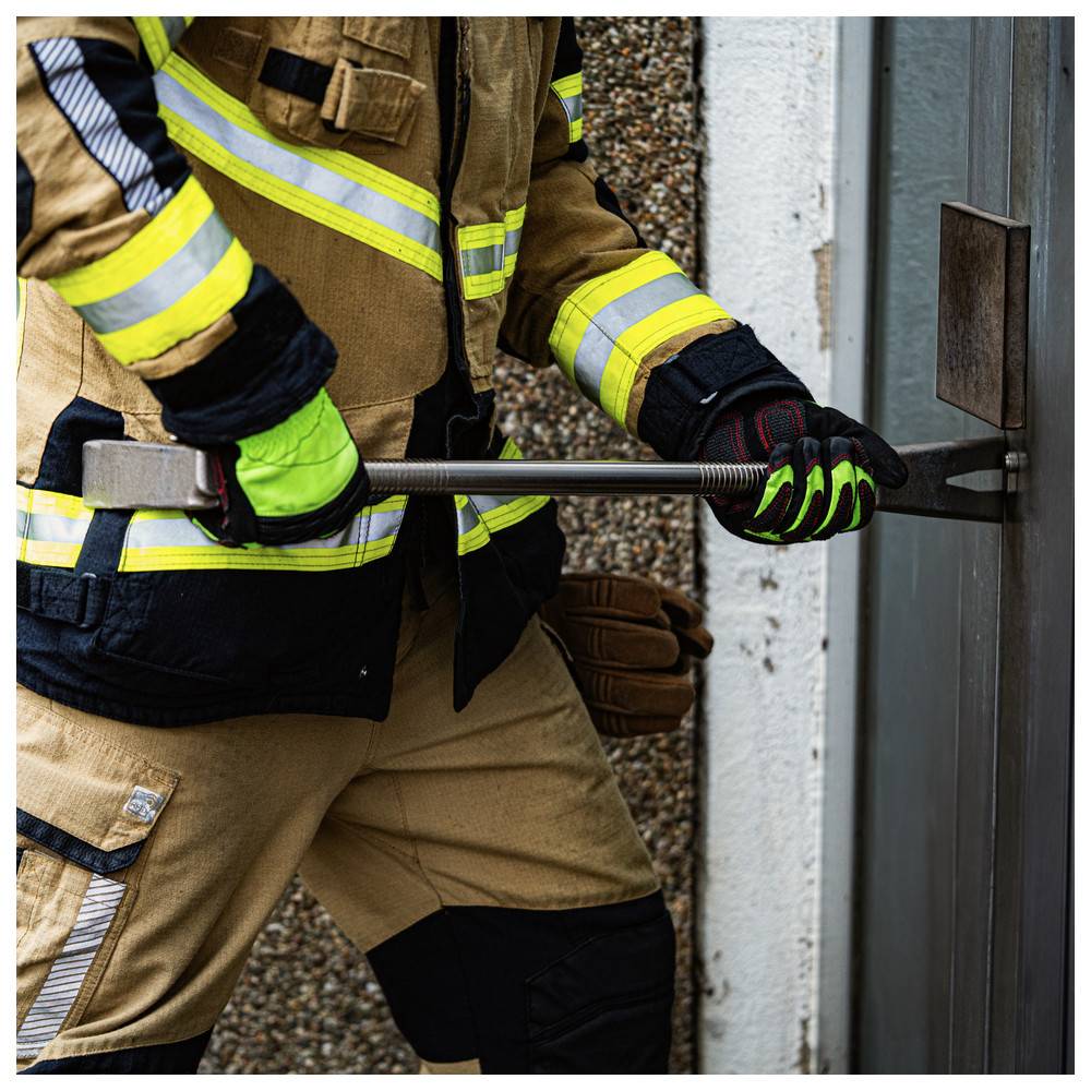 Ein Feuerwehrmann in Schutzausrüstung verwendet ein Werkzeug, um eine Tür aufzubrechen und demonstriert dabei Techniken für den Notfallzugang.
