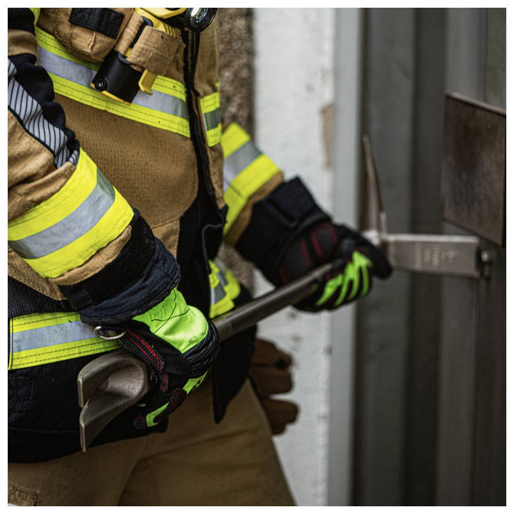 Ein Feuerwehrmann in Schutzausrüstung benutzt eine Halligan-Stange, um eine Tür aufzubrechen und damit eine Rettungstechnik zu demonstrieren.