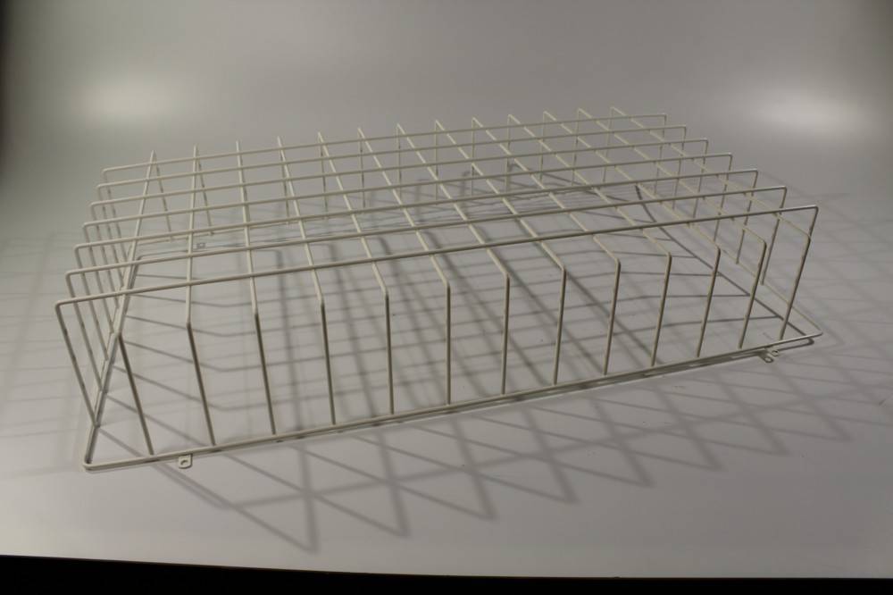 Ein weißes Drahtregalsystem, das Schatten auf einer einfarbigen Oberfläche wirft, aus einem leicht schrägen Blickwinkel betrachtet.