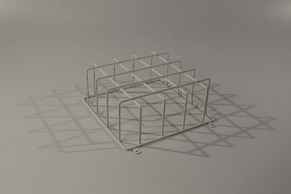 Ein weißes Metallgittergestell auf einer grauen Oberfläche wirft Schatten. Der Zweck ist unklar, möglicherweise ein Schutzabdeckung oder ein Lagerregal.