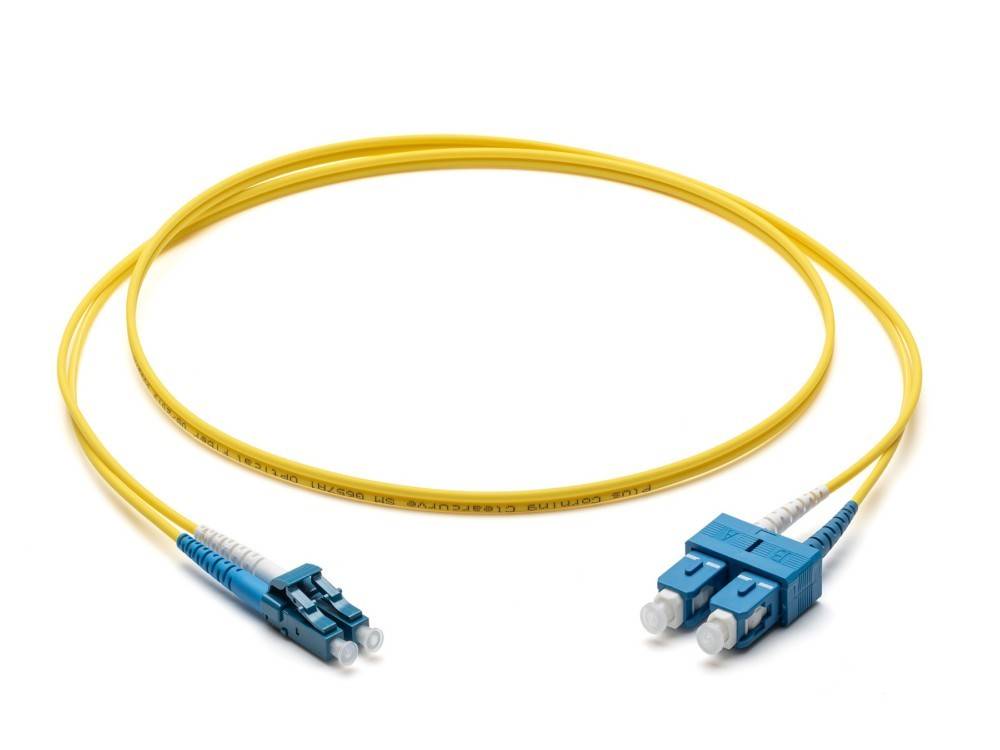 Ein gelbes Glasfaser-Patchkabel mit blauen Steckern an beiden Enden, verwendet für hochgeschwindigige Kommunikation und Datenübertragung.