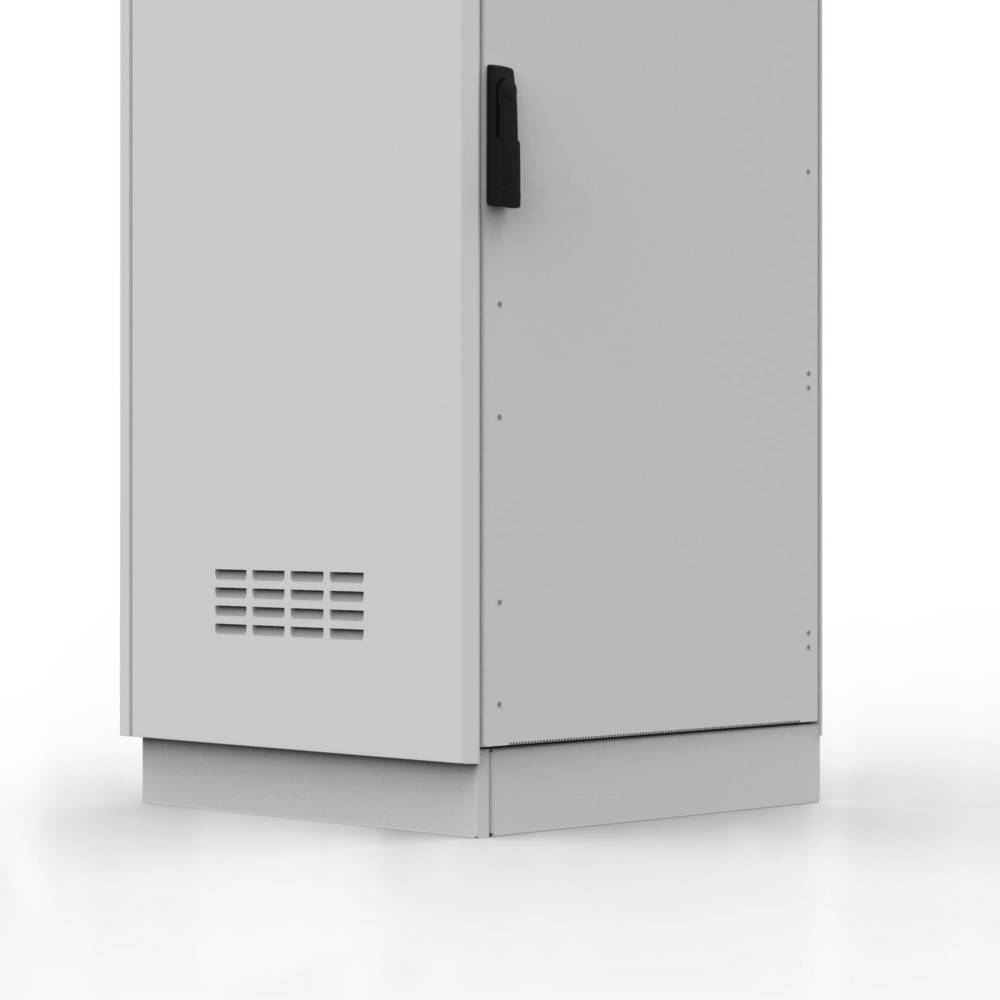 Ein grauer, rechteckiger Elektroschrank mit einer Lüftungsöffnung und einem schwarzen Griff an der Vorderseite. Der Schrank steht auf einer ebenen Oberfläche.