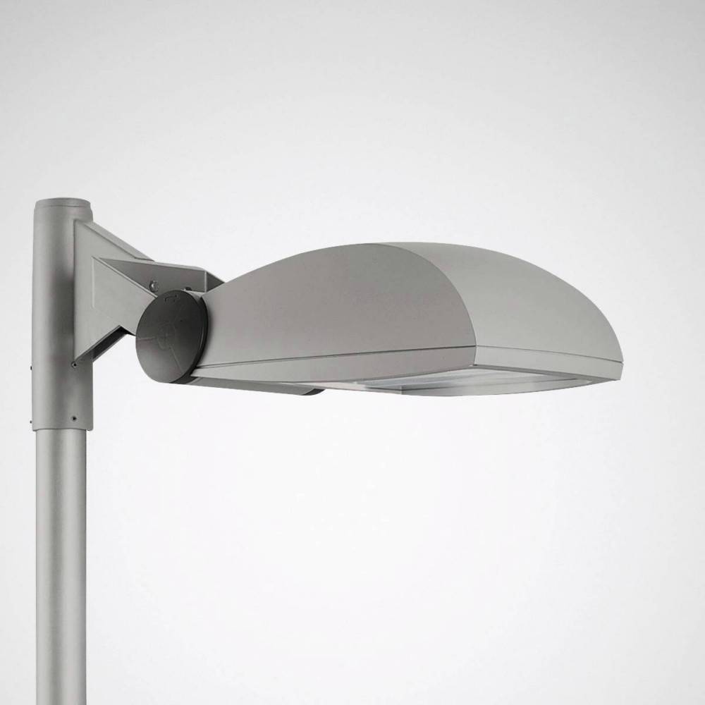 Eine moderne, silberne Straßenlaterne mit geschwungener Form, montiert auf einem Metallmast vor einem schlichten Hintergrund.