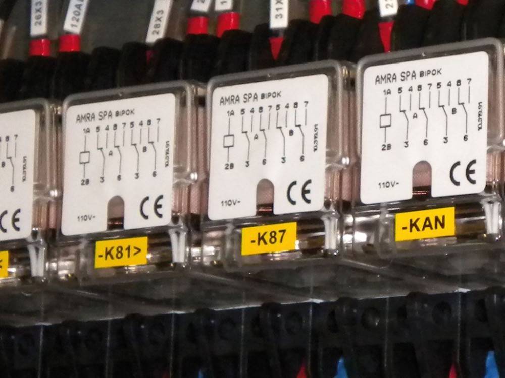 Drei elektrische Relais mit den Bezeichnungen 'K81', 'K87' und 'KAN', die Symbole für eine Spule und einen Kontakt mit den Spezifikationen '110V' und '11V' zeigen.