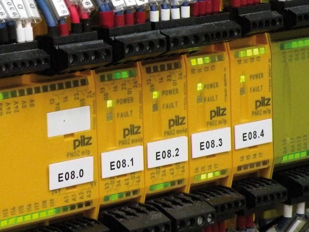 Sicherheitsrelais mit Bezeichnungen wie ‚E08.1', ‚E08.2', die den Energie- und Fehlerstatus in einem elektrischen System anzeigen.