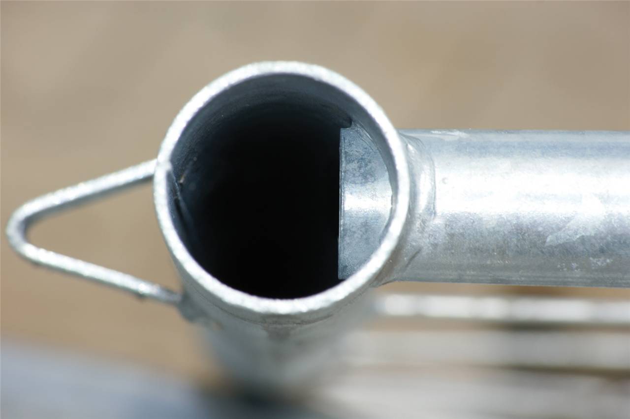 Nahaufnahme einer Metallröhre auf einem unscharfen Hintergrund. Die Röhre erscheint hohl und zylindrisch, mit einer glänzenden Oberfläche und einer Naht an der Seite.