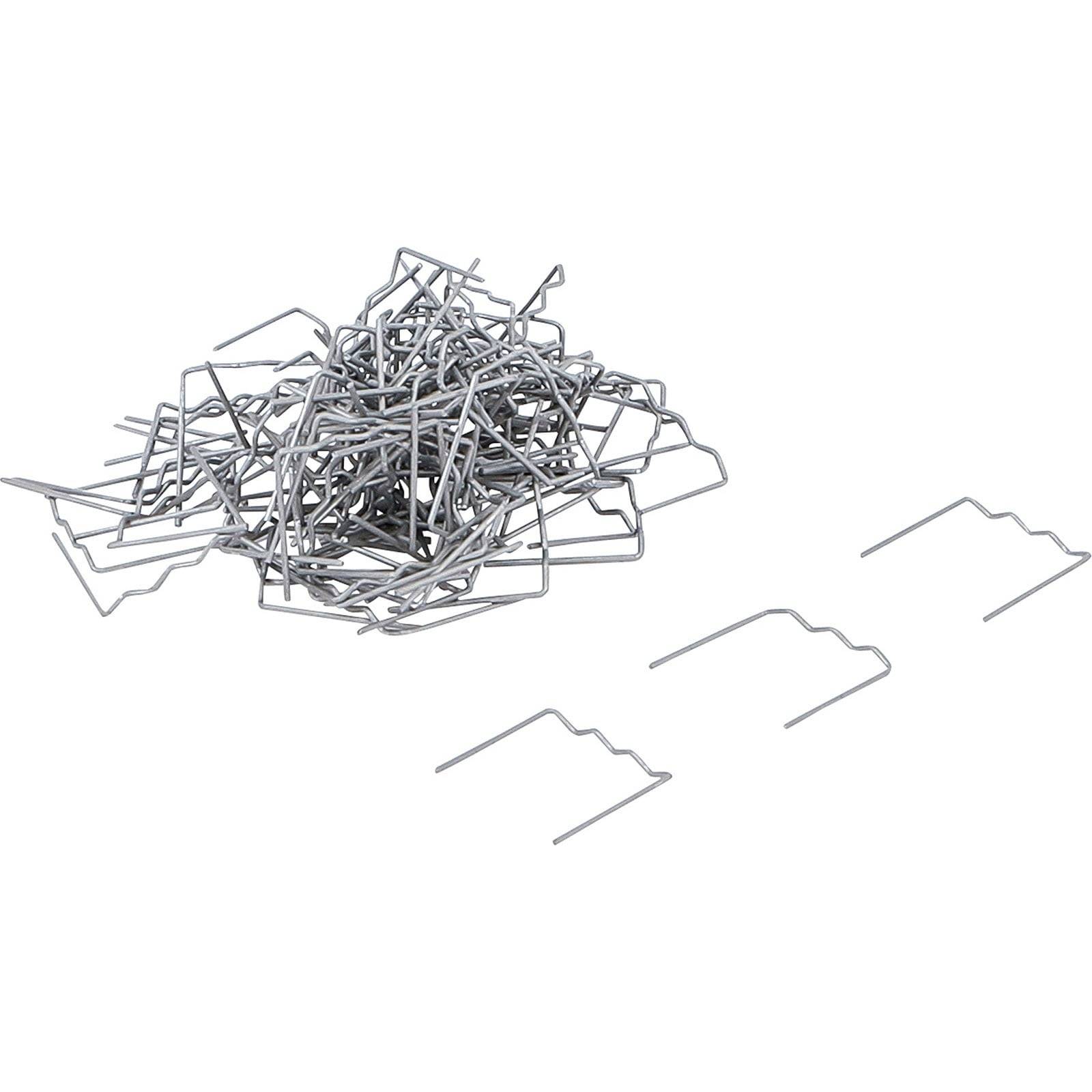 Ein Haufen Metallklammern mit einigen einzelnen Klammern daneben, die ihr Zickzack-Design präsentieren.