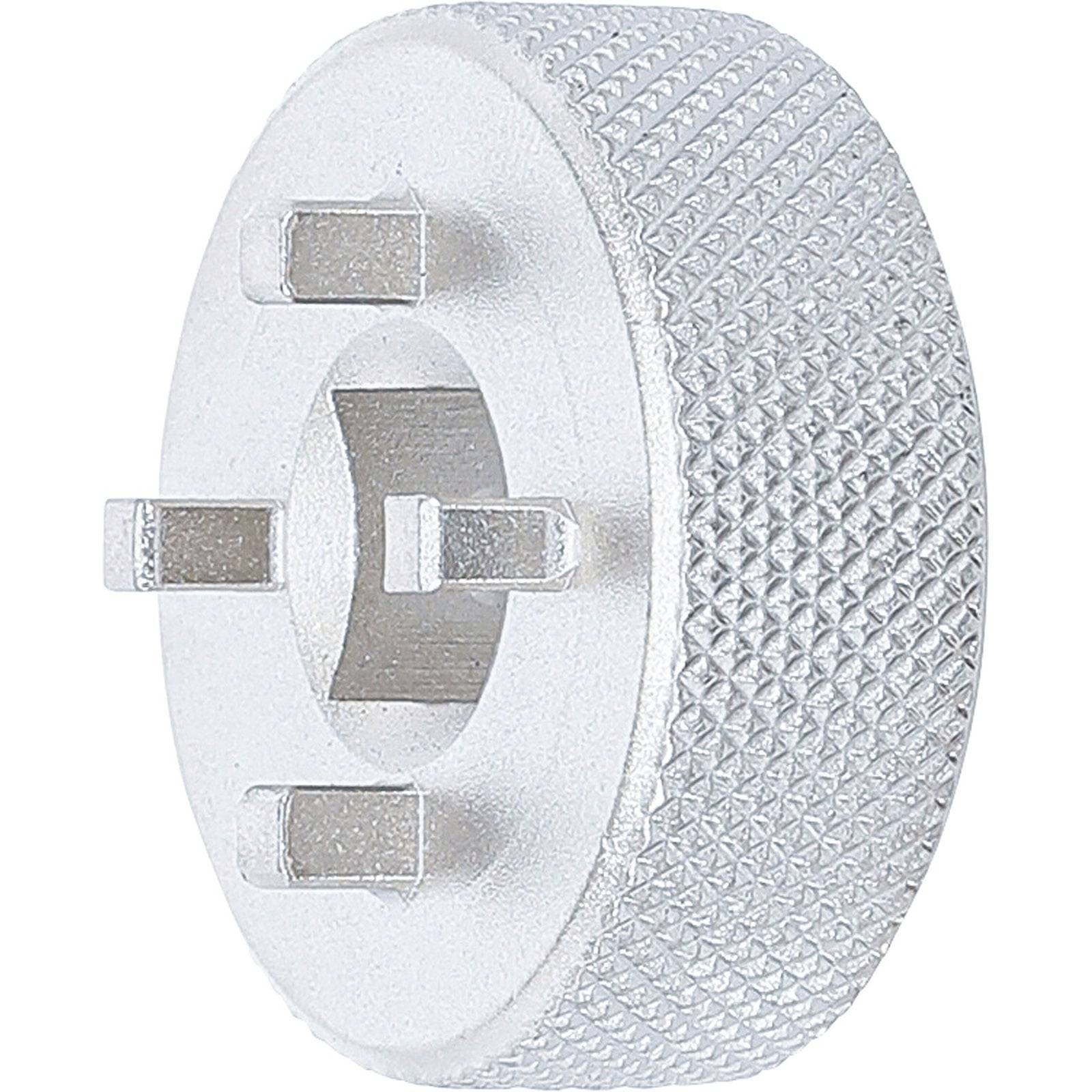 Ein kreisförmiger metallischer Klempnerschlüssel mit einem strukturierten Griff und vier hervorstehenden Kerben zum Drehen von Rohranschlüssen.