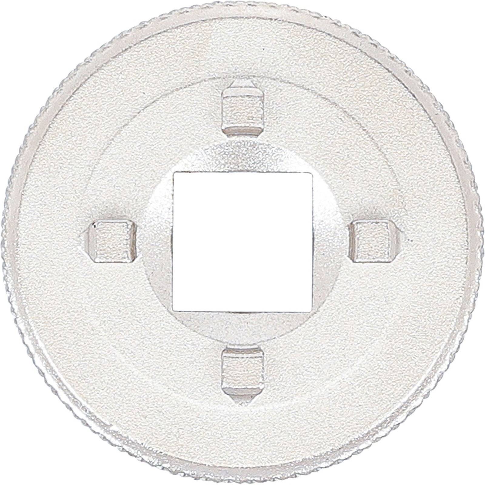 Ein metallisches rundes Objekt mit einem quadratischen Loch in der Mitte und vier symmetrisch angeordneten hervorstehenden Laschen.