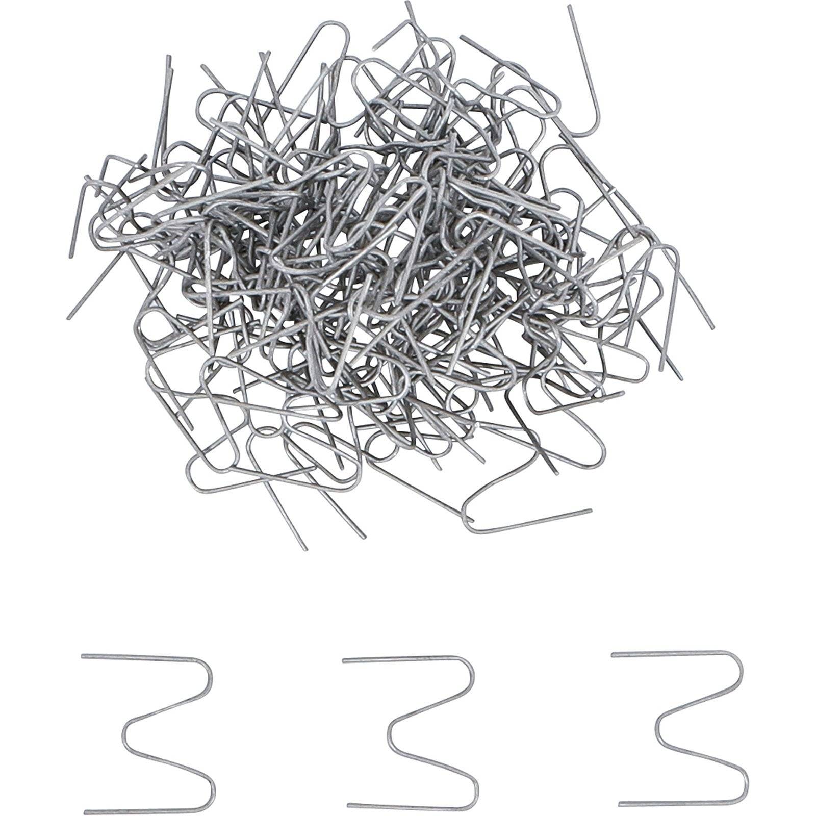 Ein Haufen silberner, U-förmiger Gartenhaken und eine Reihe von vier einzelnen Haken, die hier unten dargestellt sind und zum Befestigen von Landschaftsgewebe verwendet werden.