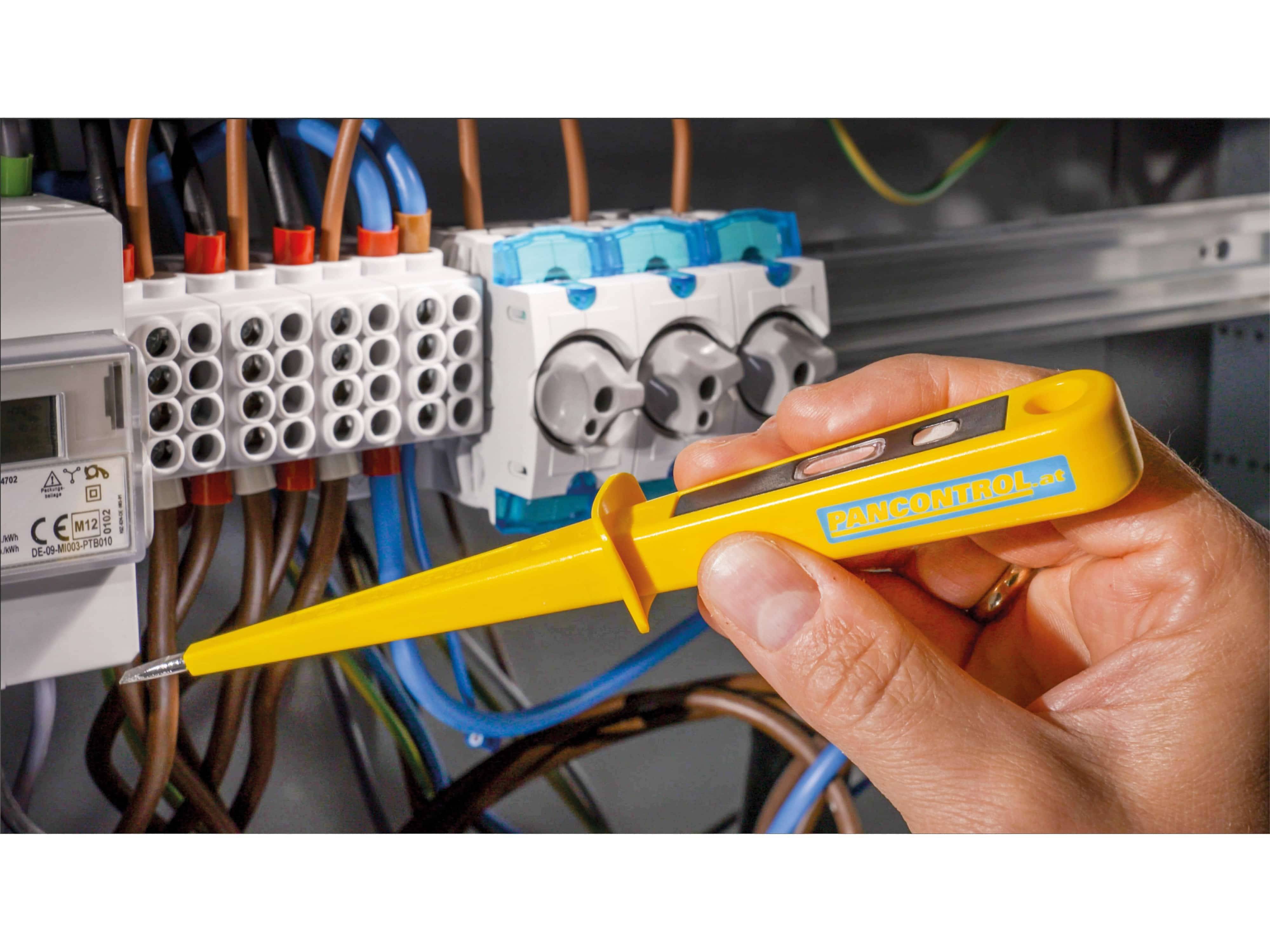 Eine Person verwendet einen gelben Spannungsprüfer an einem komplexen Elektroinstallationssystem, um sicherzustellen, dass die elektrischen Verbindungen ordnungsgemäß funktionieren.