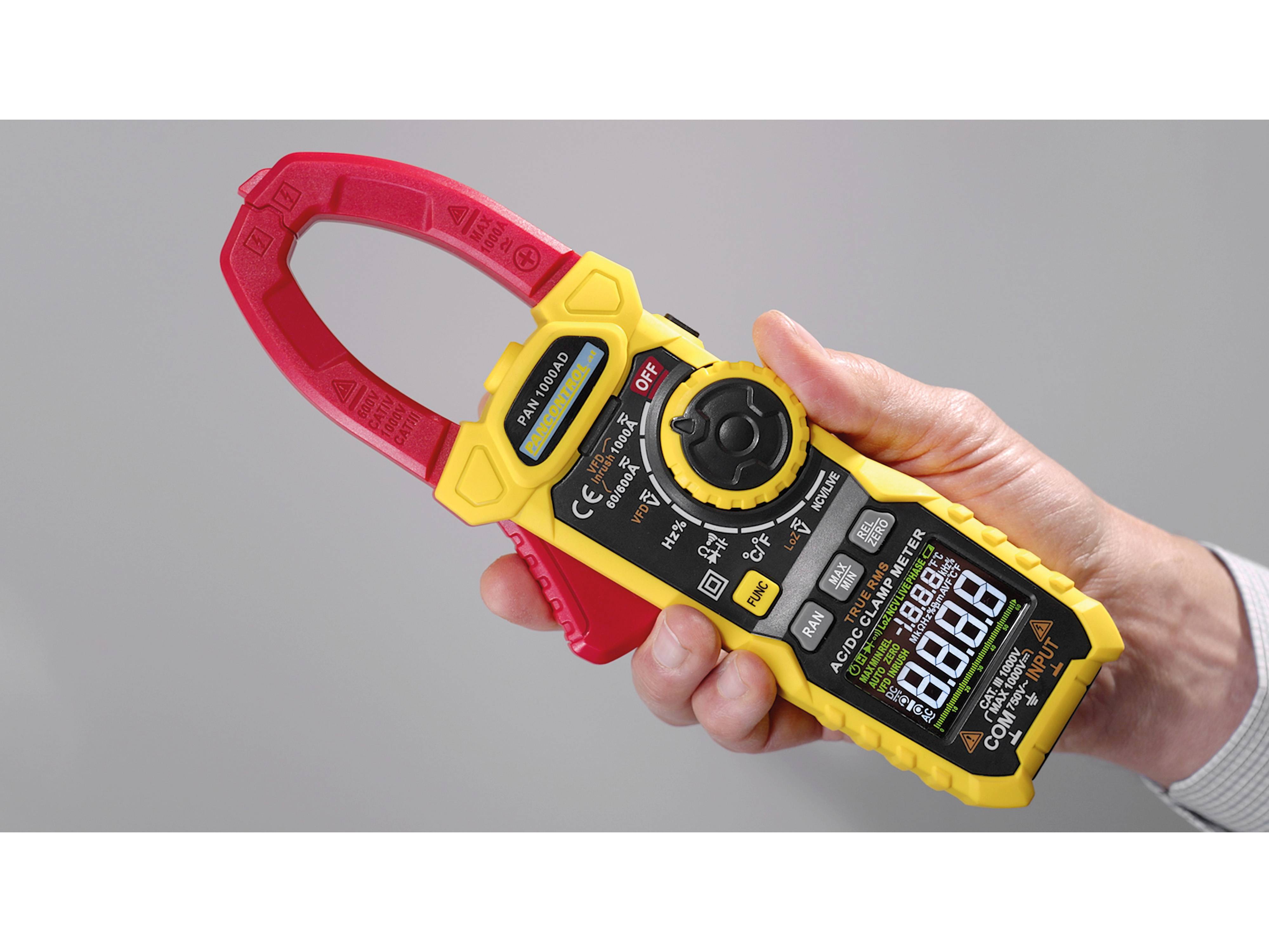 Eine Hand hält ein digitales Zangenprüfgerät mit gelbem und rotem Griff, das verschiedene Funktionen zeigt und einen digitalen Bildschirm mit numerischen Werten anzeigt.